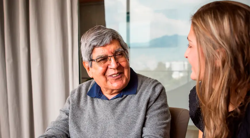 Foto de un adulto mayor hablando con una joven